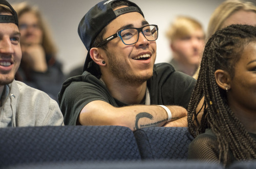 Bilde av smilende gutt i auditorium