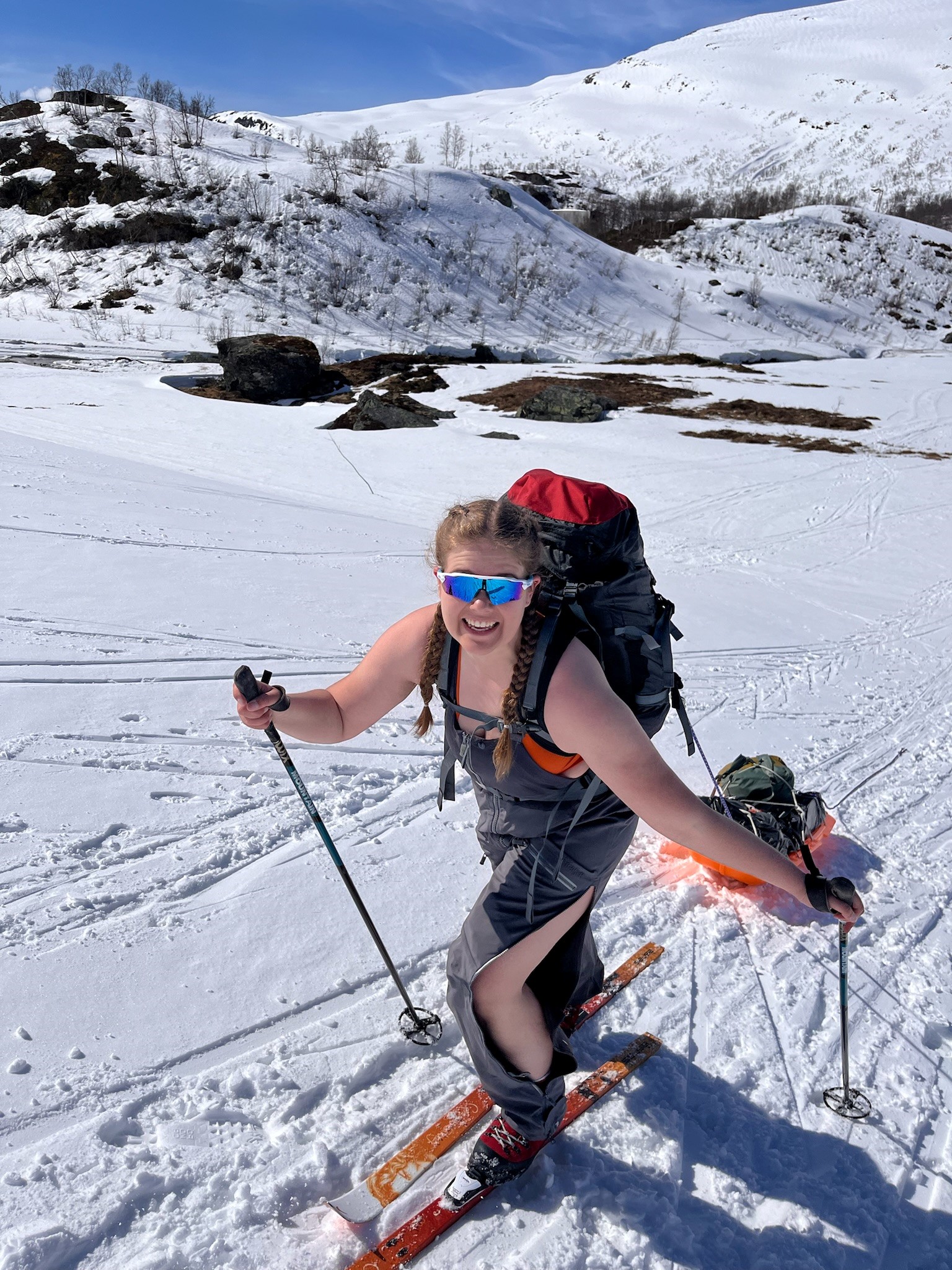 en ung kvinne som går på ski i fjellet i fint vær 