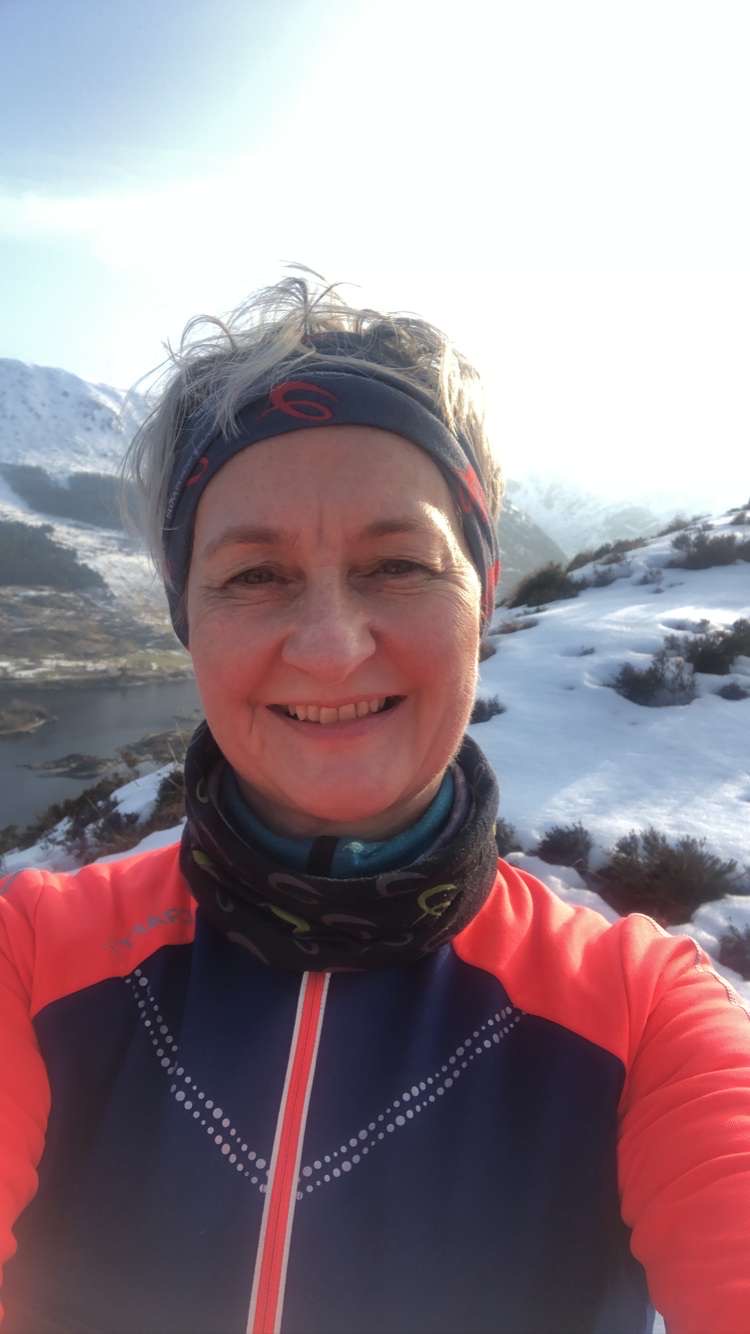 Judith, selfie på tur. Fjell med snø på i bakgrunnen