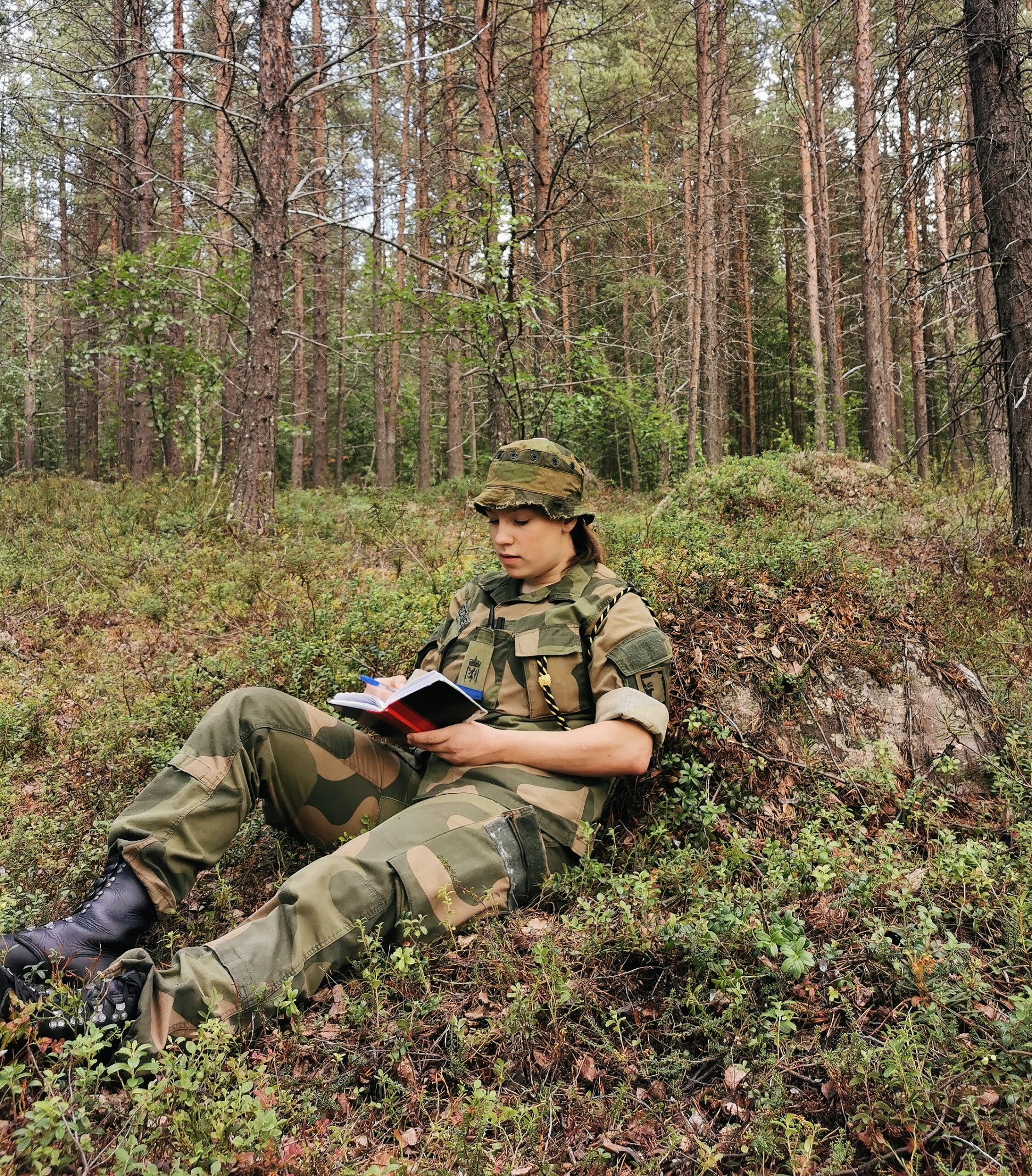 dame i militær uniform som leser en bok