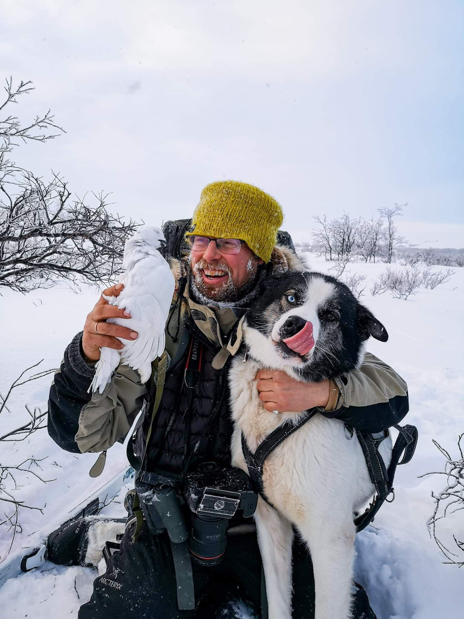 en mann på tur om vinteren med ei rype og en hund