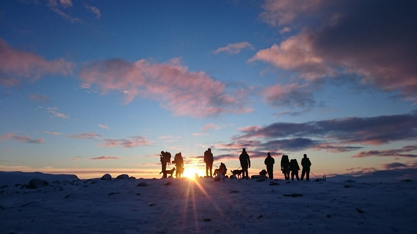 en gruppe mennesker i siluett i et vinterlandskap