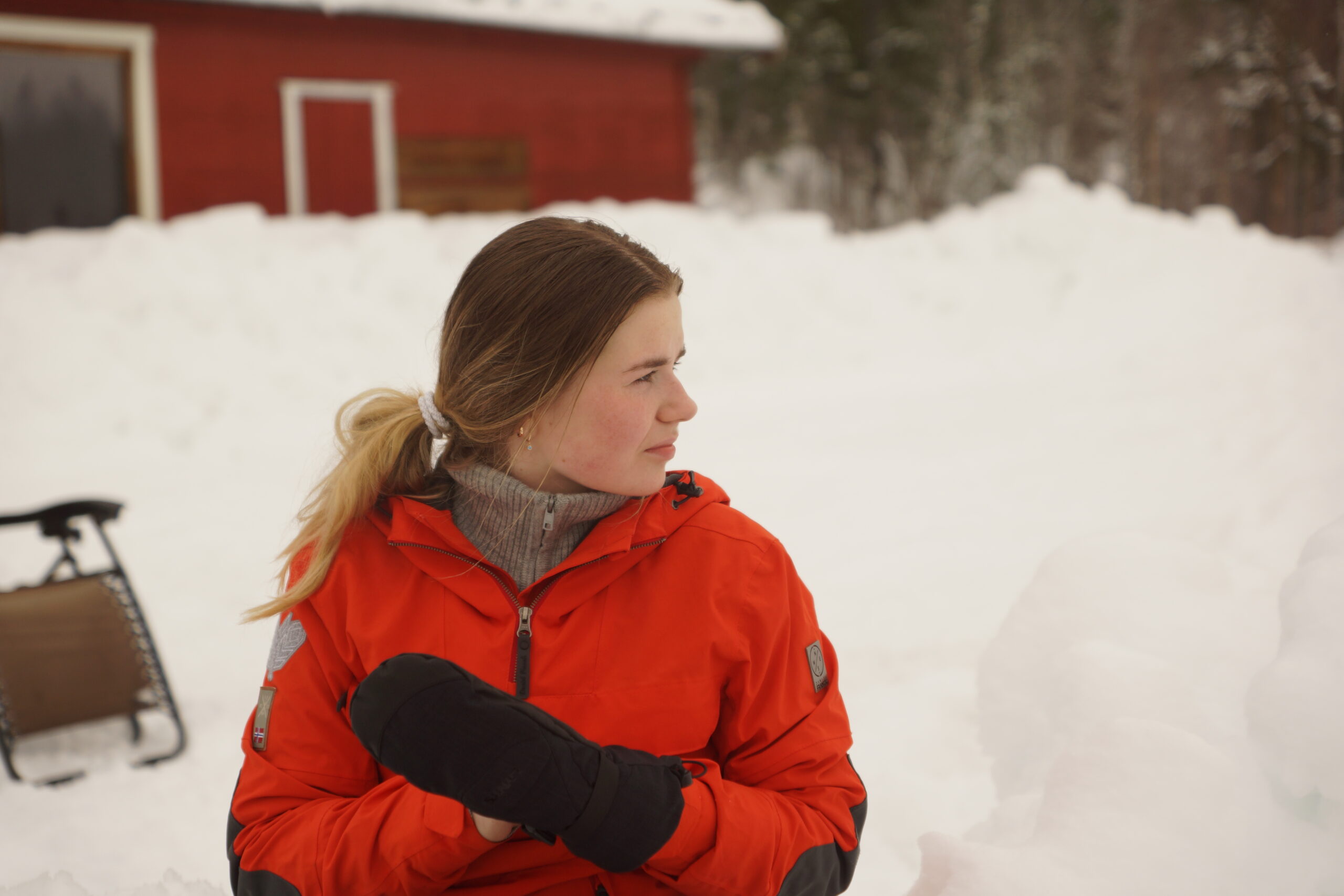 en ung kvinne i vinterjakke ute i snøen