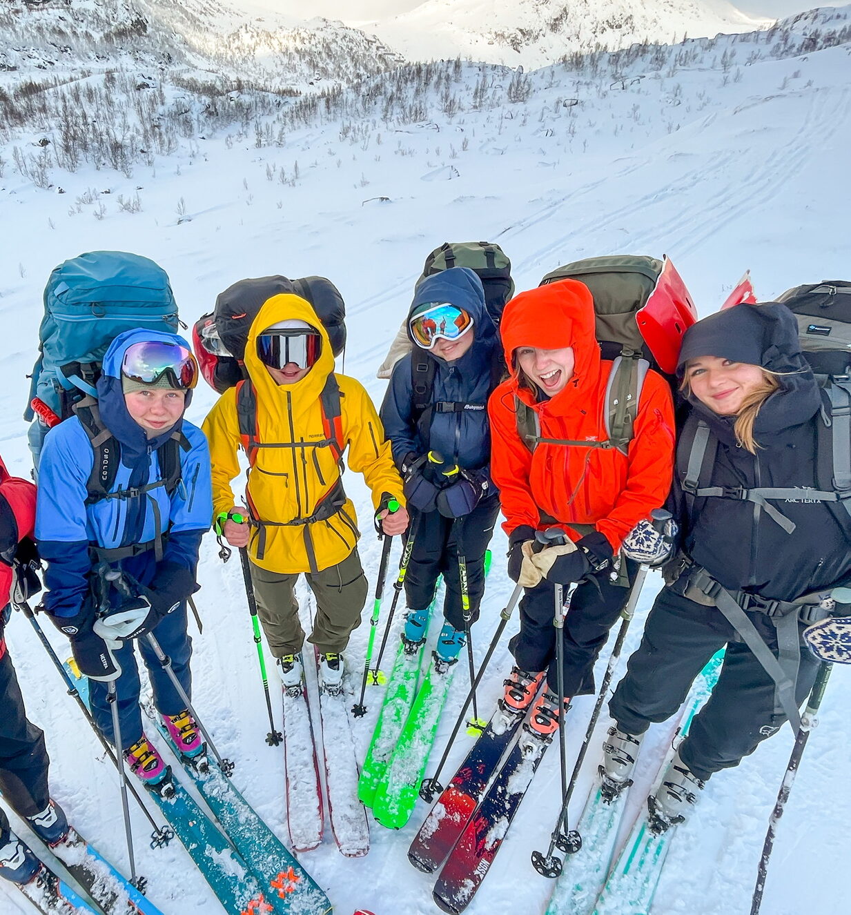 En gjeng med ungdommer i skiutstyr som står i en halvsirkel