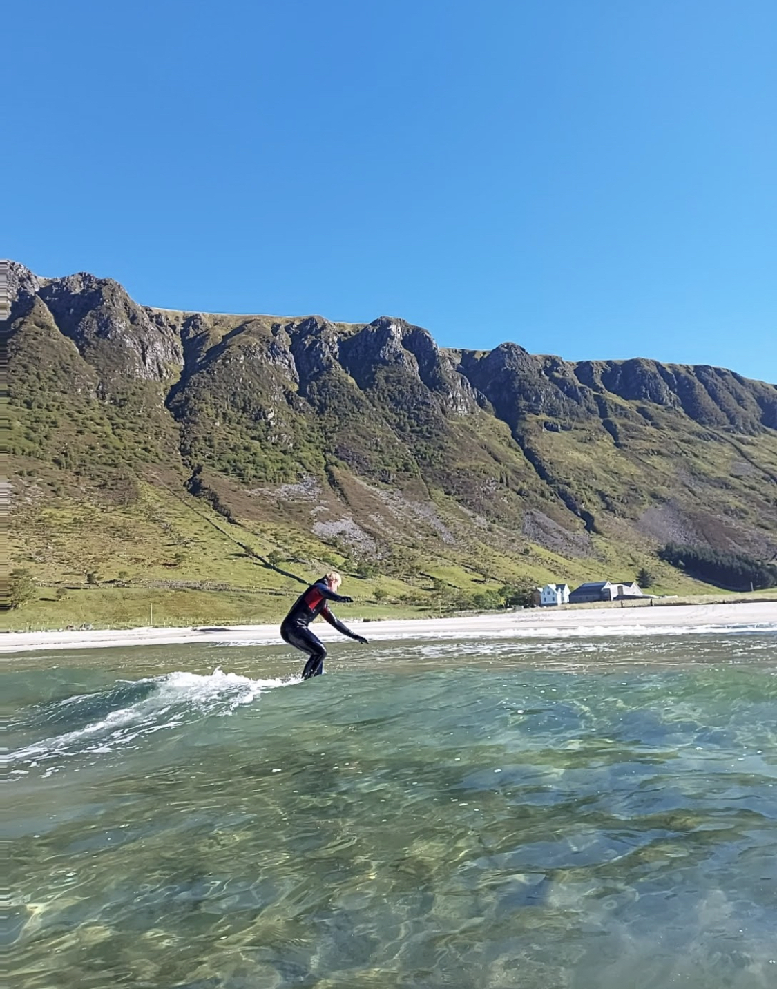 en ung mann som surfer foran et fjell 