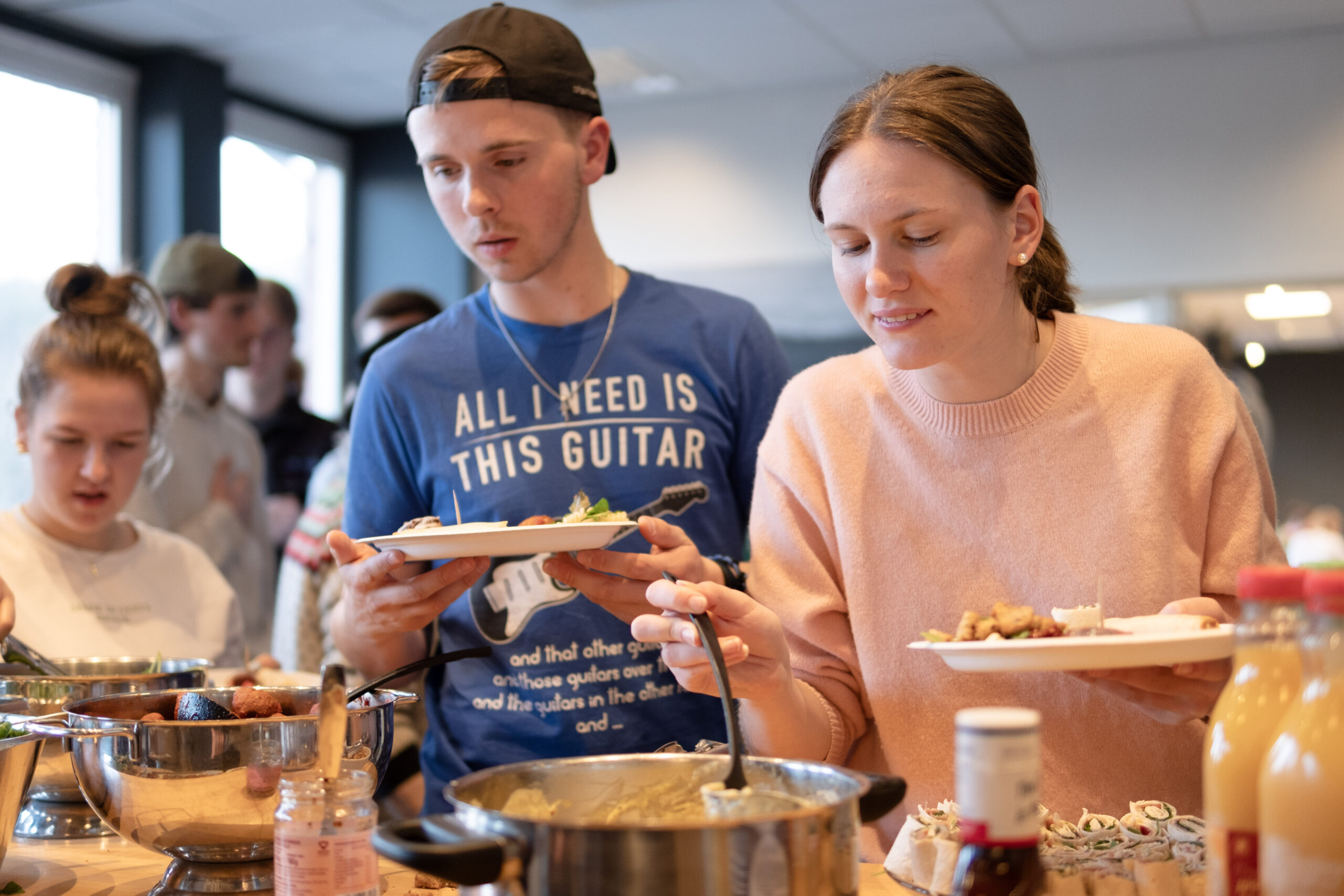 Elever tar mat ut av gryter og skoler og opp på tallerkner