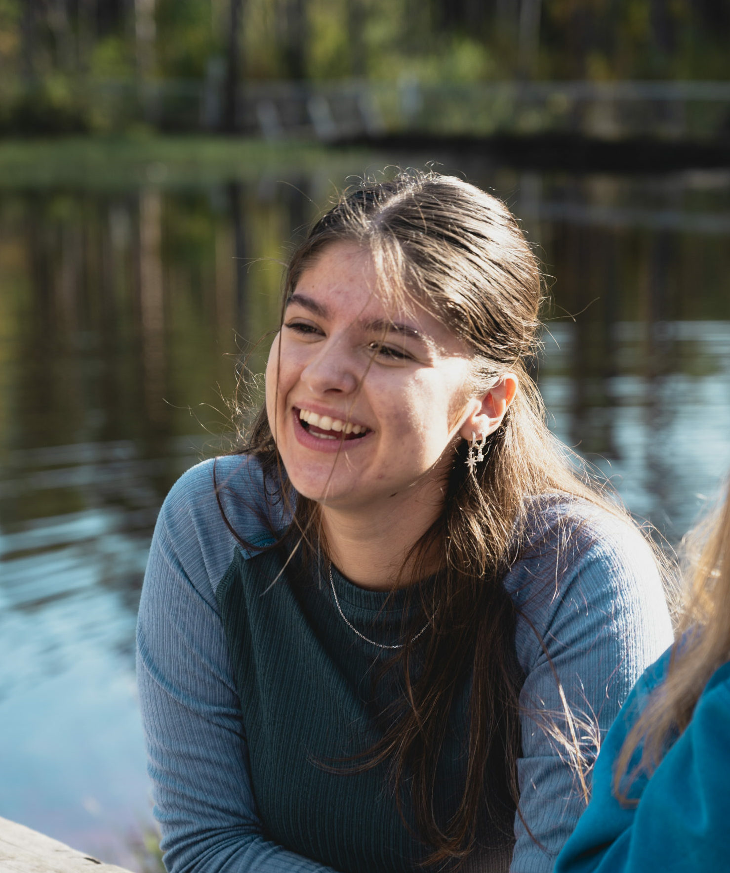 en ung kvinne sitter ved et rasteplassbord i naturen 